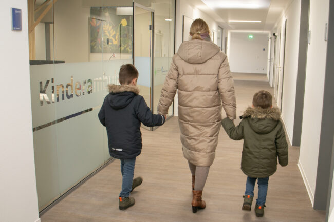 Eine Mutter mit zwei Kindern auf dem Weg in die Kinderambulanz der KVWL-Notdienstpraxis am KlinikumStadtSoest