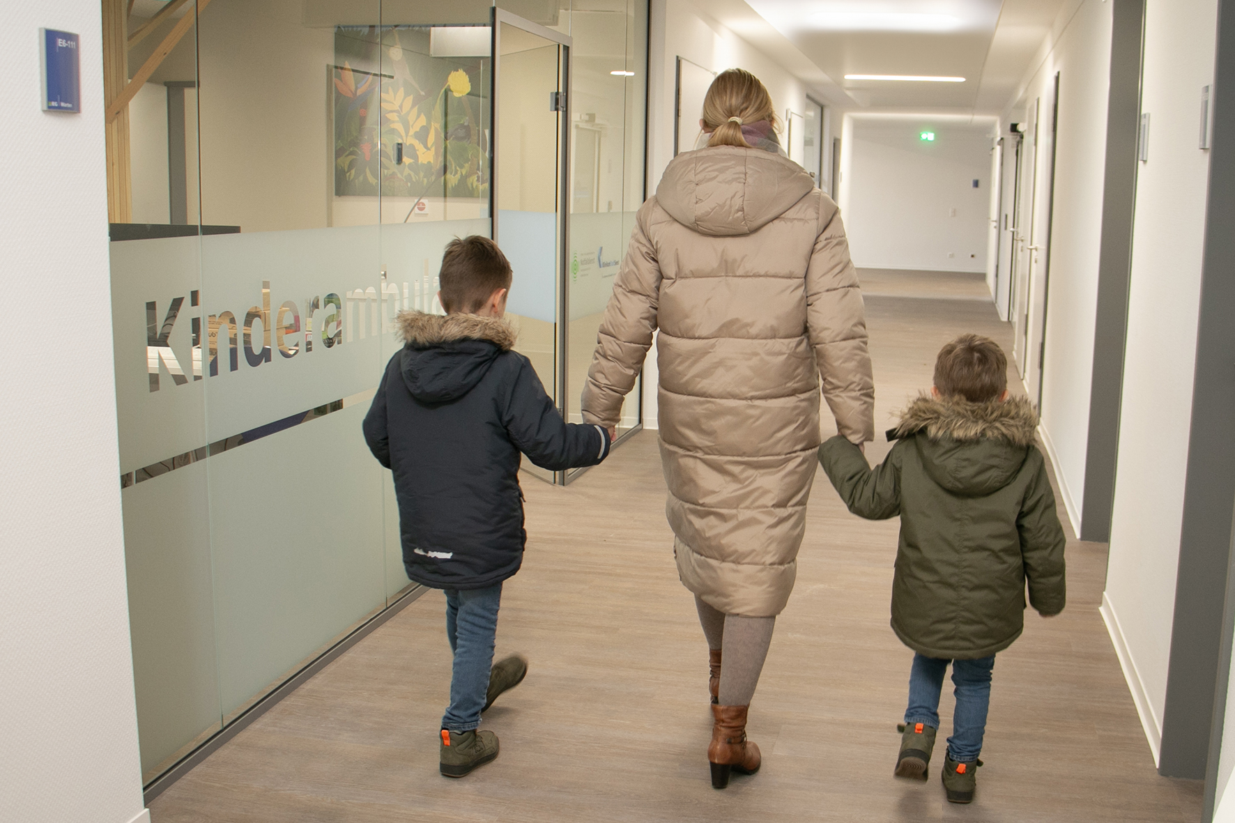 Eine Mutter mit zwei Kindern auf dem Weg in die Kinderambulanz der KVWL-Notdienstpraxis am KlinikumStadtSoest