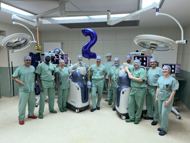 PD Dr. Klotz und sein Team mit den beiden OP-Robotern in einem OP-Saal des Christlichen Klinikums Soest
