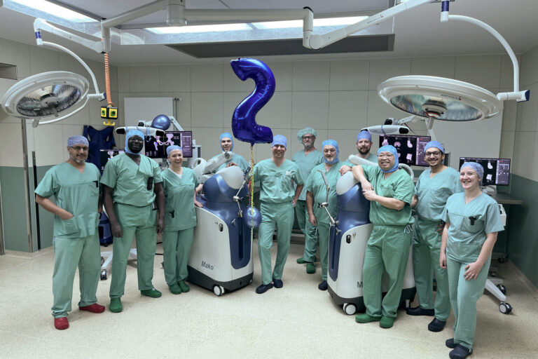 PD Dr. Klotz und sein Team mit den beiden OP-Robotern in einem OP-Saal des Christlichen Klinikums Soest