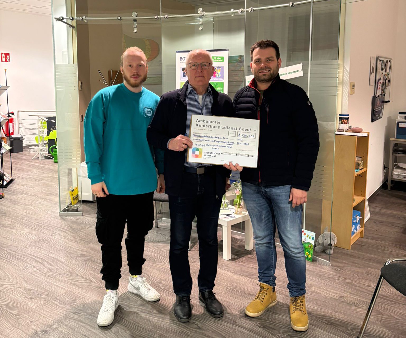 Sebastian Korte (links) und Dennis Bloch (rechts) übergeben den Scheck stellvertretend für die 38-köpfige Tippgemeinschaft an Hospizdienst-Mitarbeiter Dieter Rissler.